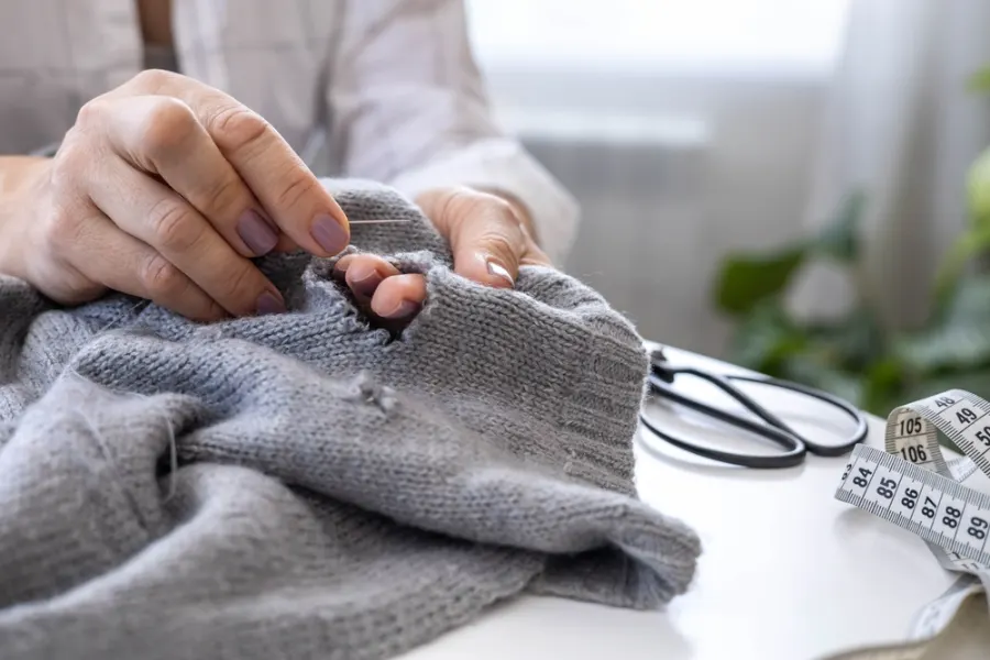 Clothing repair and alteration work with needle and scissors